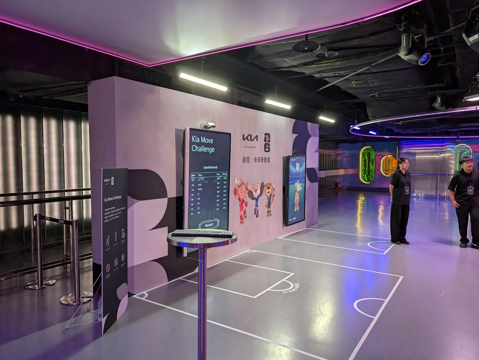 The whole station: the leaderboard on screen, the instruction panel, and a keyboard on a stand