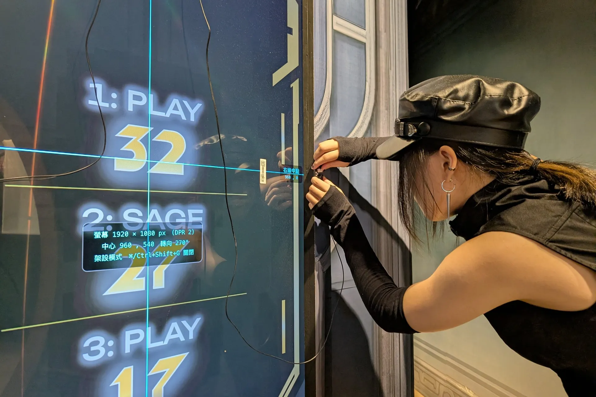 A crew member fits a sensor at the edge of the screen, following guide lines drawn by the setup mode