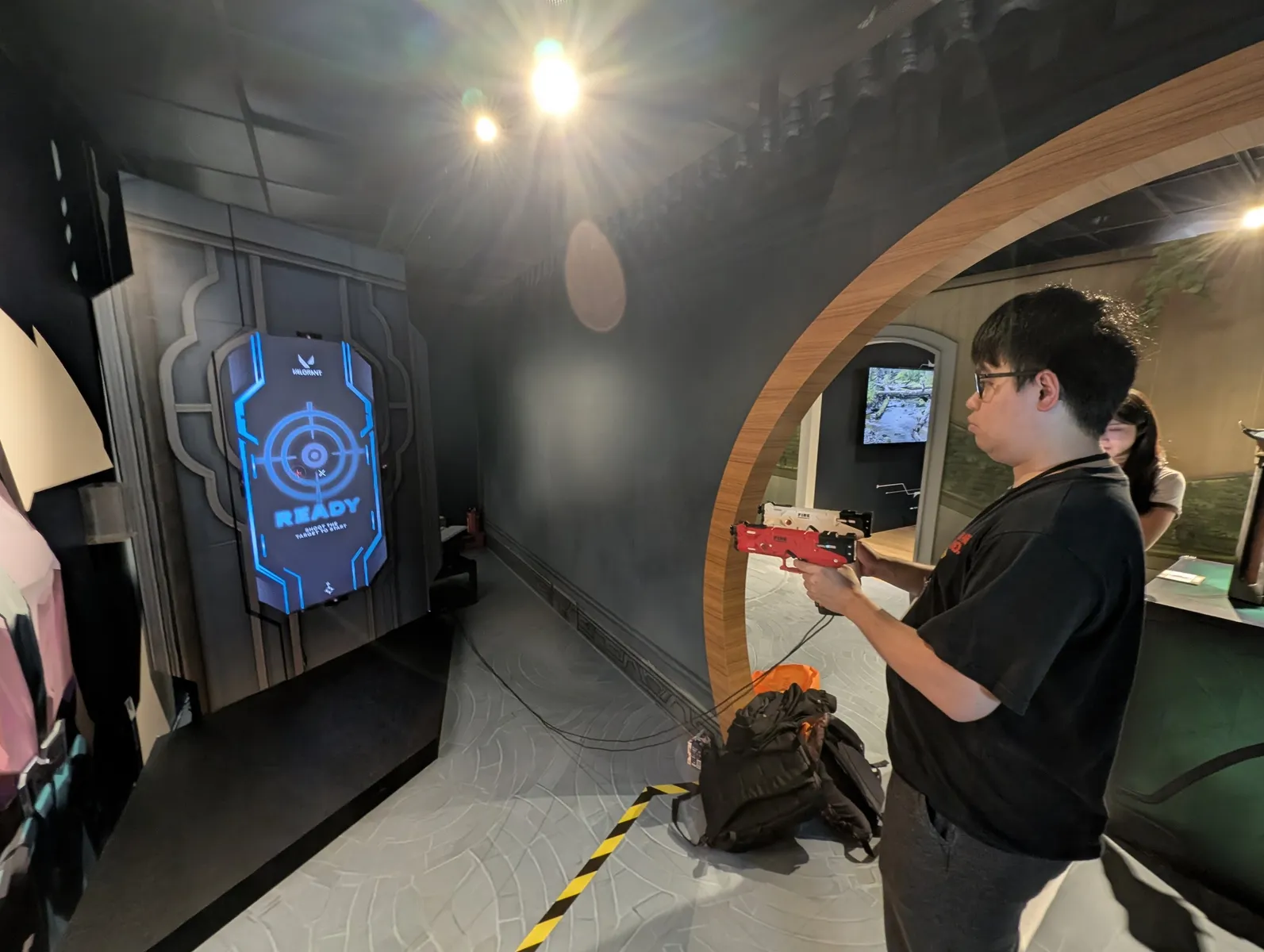 A visitor holds the red light gun in front of the READY screen